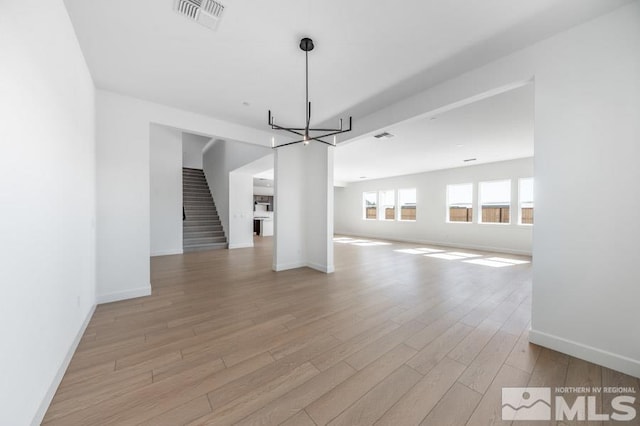 unfurnished dining area featuring a chandelier and light hardwood / wood-style floors