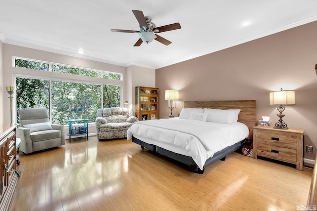 bedroom featuring light wood-type flooring, crown molding, and ceiling fan