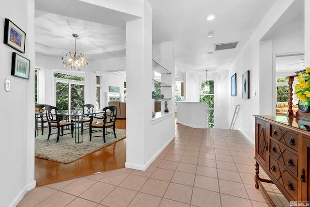 entrance foyer with a wealth of natural light, a chandelier, and light hardwood / wood-style floors