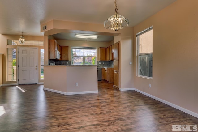 kitchen with pendant lighting, backsplash, a chandelier, and dark hardwood / wood-style flooring