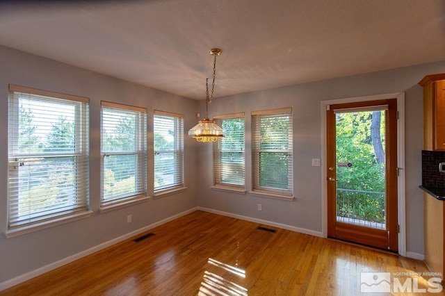 unfurnished dining area featuring plenty of natural light and light hardwood / wood-style floors