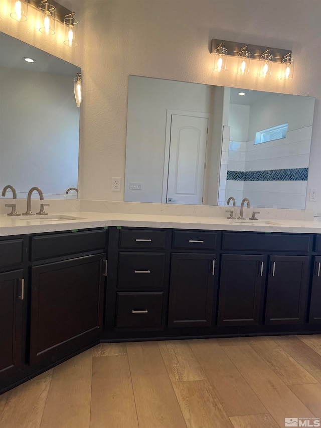 bathroom featuring vanity, a tile shower, and hardwood / wood-style floors