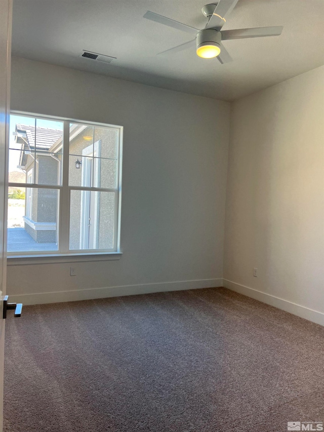 carpeted spare room with ceiling fan