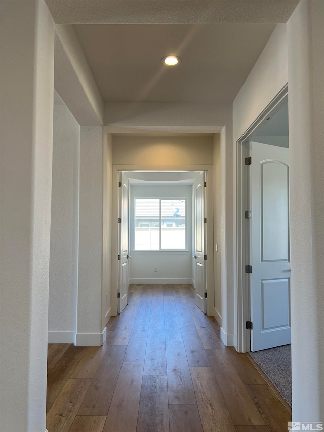 corridor with hardwood / wood-style flooring