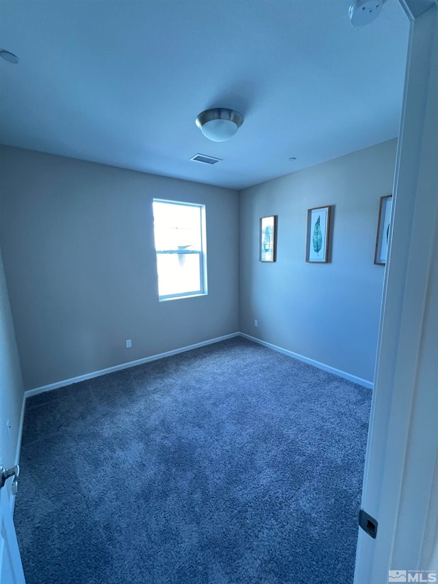 empty room with dark colored carpet