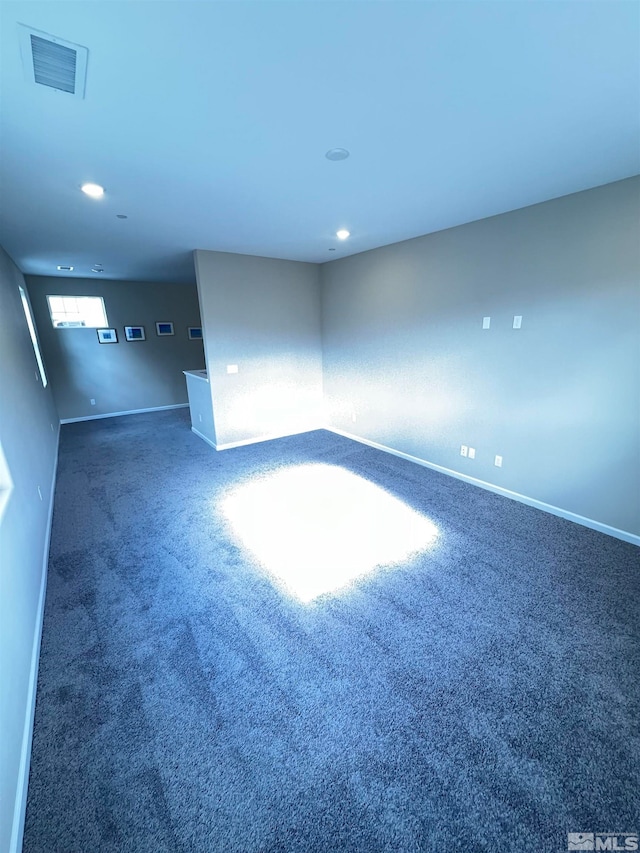 unfurnished room featuring dark carpet