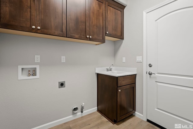 washroom featuring hookup for an electric dryer, sink, hookup for a gas dryer, washer hookup, and light hardwood / wood-style flooring