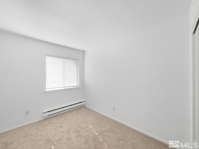 unfurnished room with a baseboard heating unit and light colored carpet