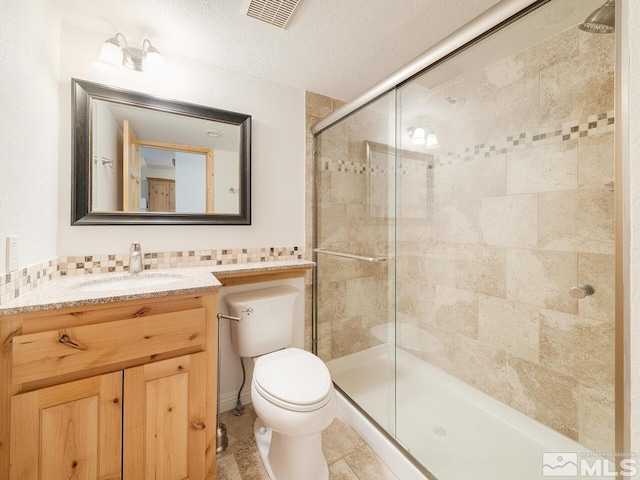 bathroom featuring toilet, an enclosed shower, tile patterned flooring, vanity, and a textured ceiling