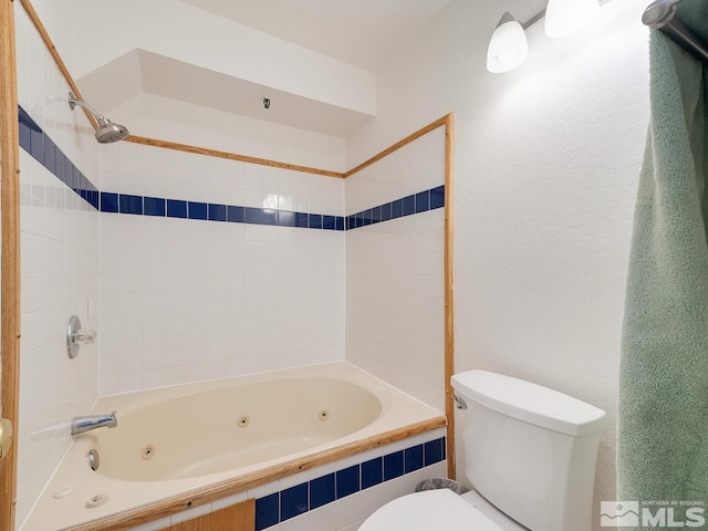 bathroom featuring tiled shower / bath and toilet