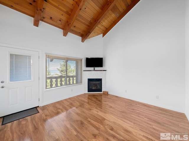 unfurnished living room featuring light hardwood / wood-style flooring, a tile fireplace, wooden ceiling, and lofted ceiling with beams