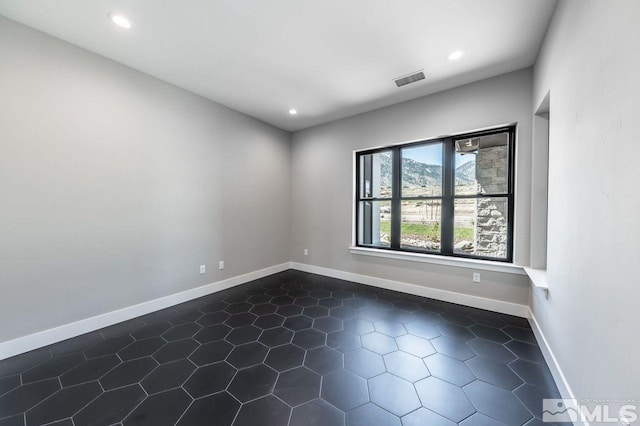 empty room featuring dark tile patterned floors