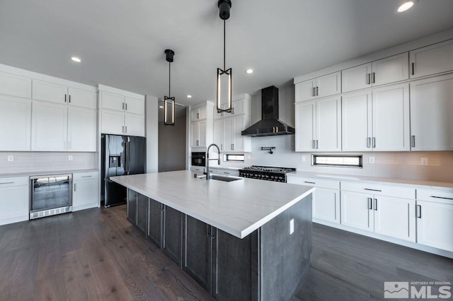 kitchen with wall chimney exhaust hood, refrigerator with ice dispenser, beverage cooler, sink, and white cabinetry