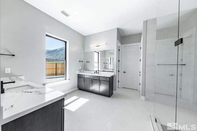 bathroom with vanity, tile patterned floors, and a tile shower