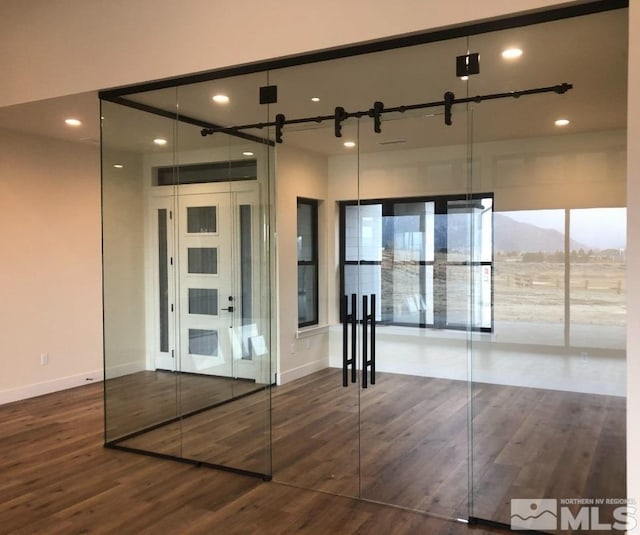 interior space with a barn door, a mountain view, and dark hardwood / wood-style floors