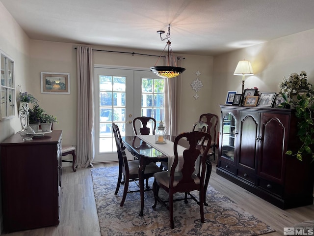 dining space with light hardwood / wood-style flooring and french doors