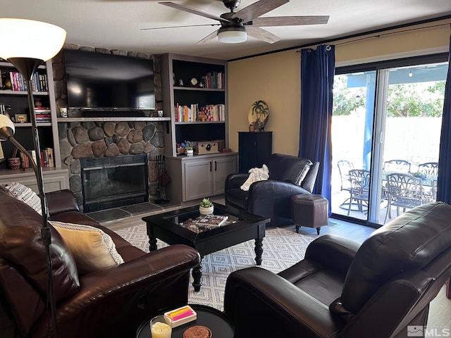 living room featuring a fireplace, a textured ceiling, and ceiling fan