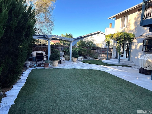 view of yard featuring french doors, a pergola, and a patio