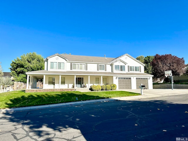 view of front of property with a garage, a front yard, and a porch