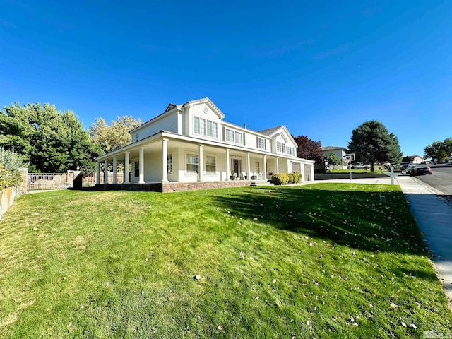 rear view of property featuring a yard and covered porch