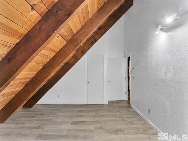 additional living space with beamed ceiling, light wood-type flooring, and wooden ceiling