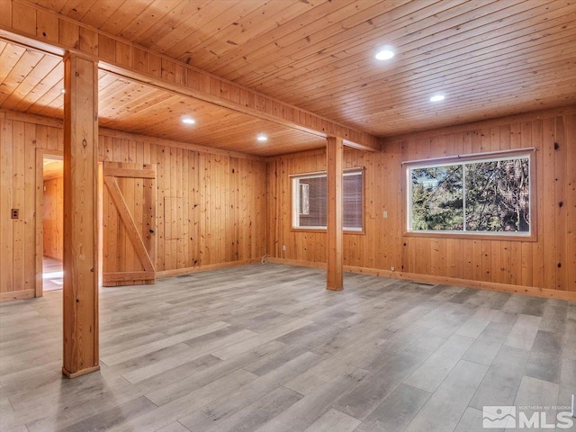 basement with light wood-type flooring, wood walls, and wooden ceiling