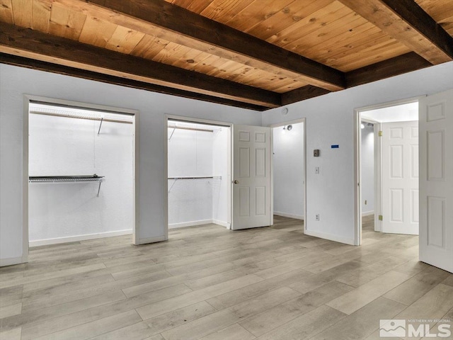 unfurnished bedroom featuring wood ceiling, beam ceiling, two closets, and light hardwood / wood-style floors