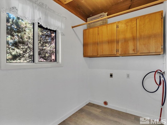 clothes washing area featuring hookup for a washing machine, plenty of natural light, cabinets, and light hardwood / wood-style flooring