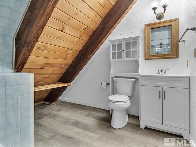 bathroom featuring vanity, toilet, wood-type flooring, and vaulted ceiling