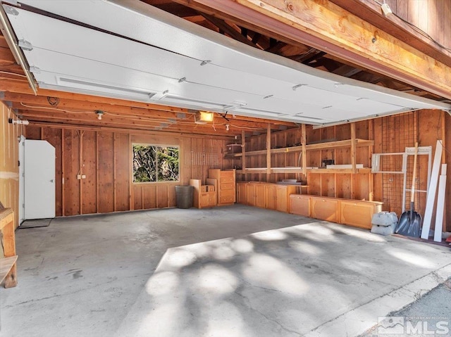 garage featuring wood walls and a garage door opener