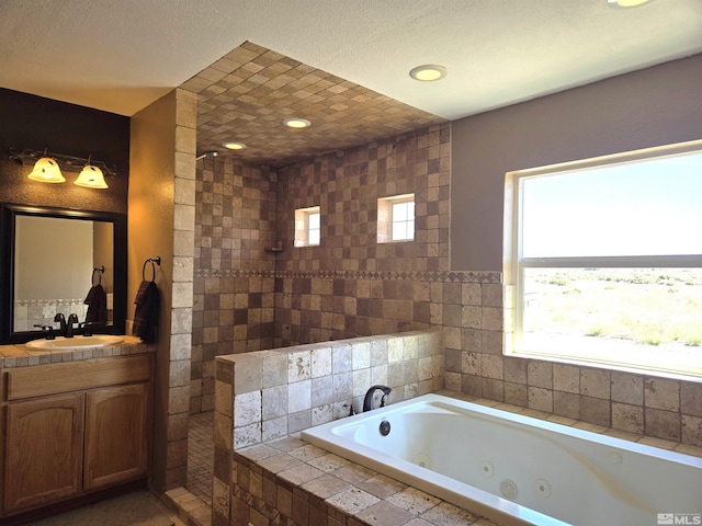 full bathroom with a tub with jets, recessed lighting, and vanity