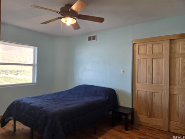 bedroom with visible vents, wood finished floors, and a ceiling fan