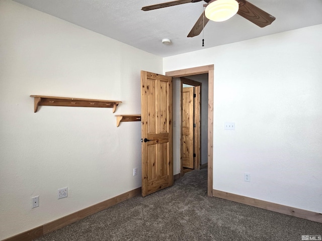 carpeted empty room featuring a ceiling fan and baseboards