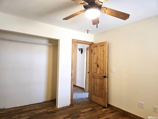 unfurnished bedroom featuring dark wood-type flooring, baseboards, a closet, and ceiling fan