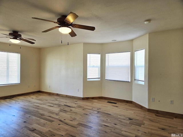 spare room with visible vents, baseboards, and wood finished floors