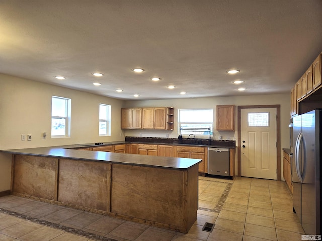 kitchen featuring dark countertops, recessed lighting, a peninsula, stainless steel appliances, and open shelves