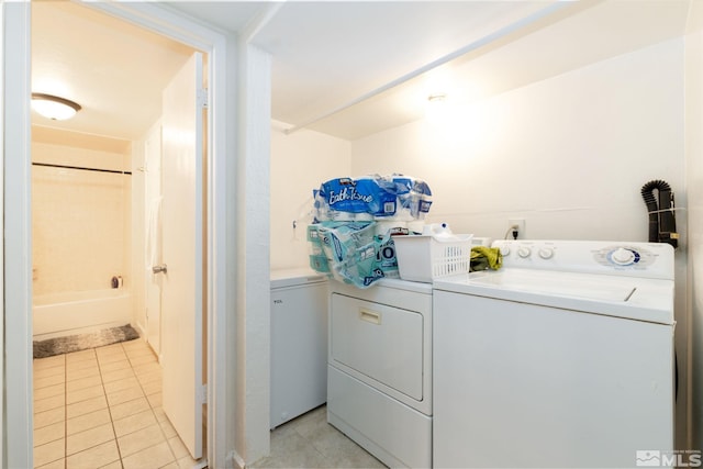 clothes washing area with washing machine and clothes dryer and light tile patterned floors