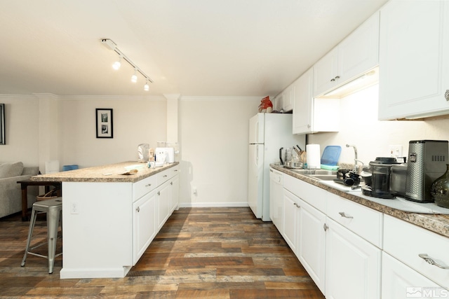 kitchen with track lighting, white cabinetry, kitchen peninsula, a kitchen bar, and dark hardwood / wood-style flooring