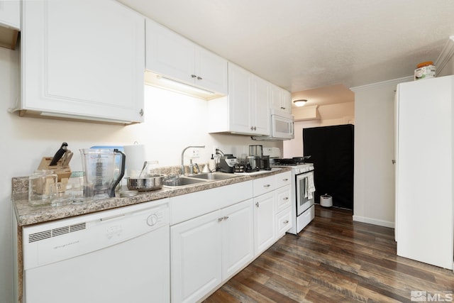 kitchen with white cabinets, sink, white appliances, a textured ceiling, and dark wood-type flooring