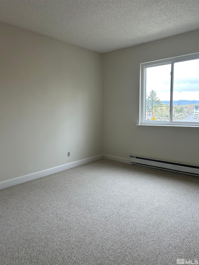 empty room with a baseboard radiator, carpet flooring, and a textured ceiling