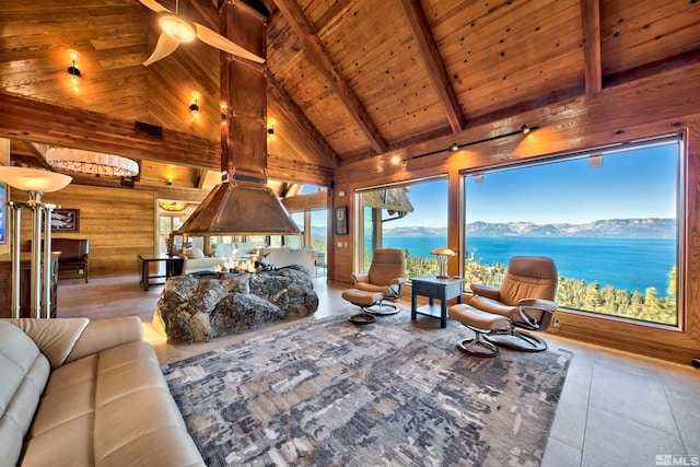 living room with ceiling fan, wood walls, beam ceiling, a water and mountain view, and high vaulted ceiling