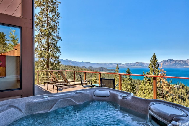 view of swimming pool featuring a hot tub and a water and mountain view