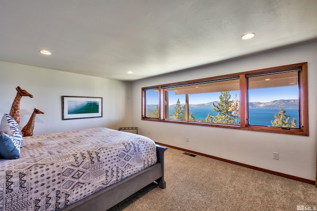 bedroom featuring a water and mountain view and carpet