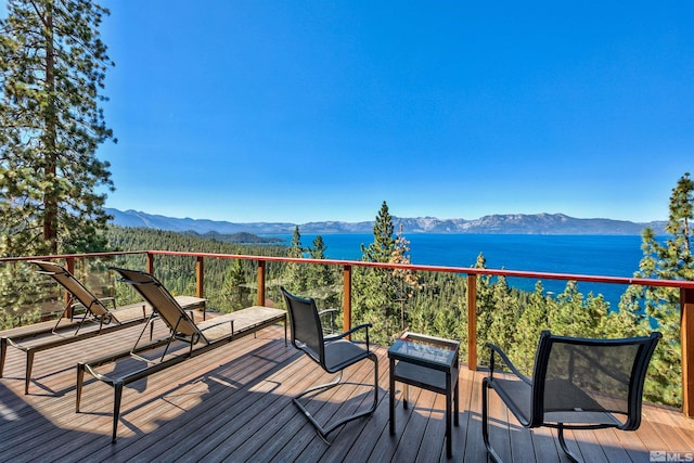 wooden terrace with a water and mountain view