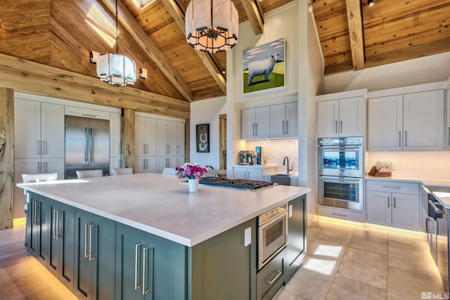 kitchen featuring hanging light fixtures, high vaulted ceiling, stainless steel appliances, an inviting chandelier, and a center island