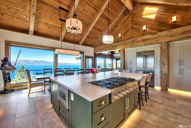 kitchen with high vaulted ceiling, a kitchen island, built in appliances, beamed ceiling, and decorative light fixtures