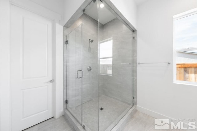 bathroom featuring tile patterned floors and a shower with shower door