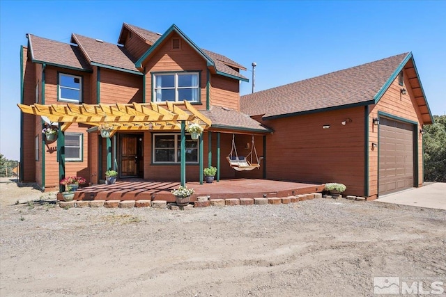 view of front of property featuring a pergola and a garage