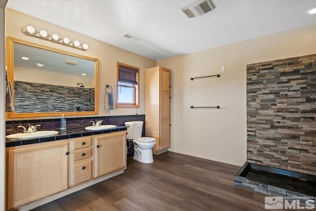 bathroom with vanity, toilet, a textured ceiling, and hardwood / wood-style flooring