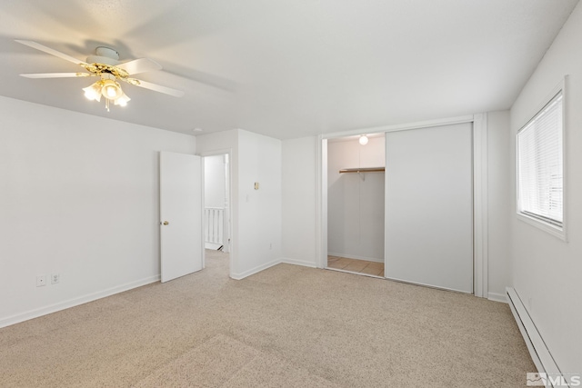 unfurnished bedroom featuring light carpet, a closet, ceiling fan, and baseboard heating